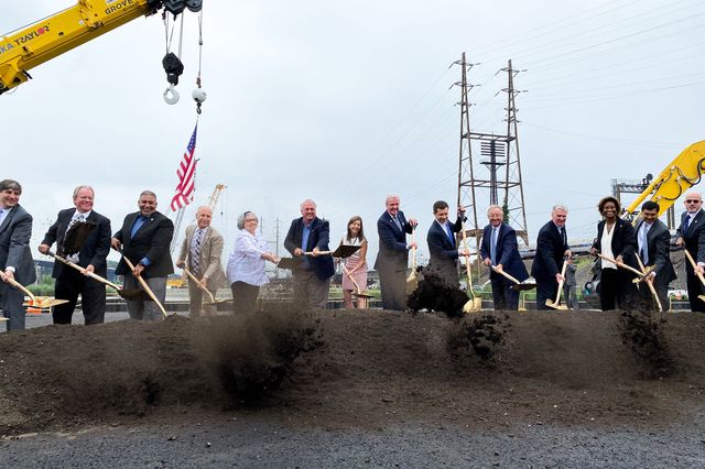 Officials including New Jersey Gov. Phil Murphy and U.S. Secretary of Transportation Pete Buttigieg (seventh and sixth from right) celebrate the start of construction for the Portal North Bridge with a groundbreaking.